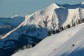 A person skiing down a steep slope terrain in the Rockies.